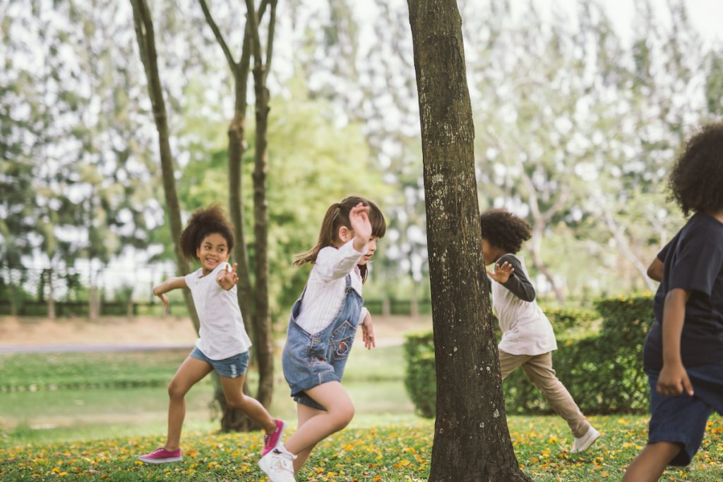 kids playing outdoors with friends. little children play at nature park.