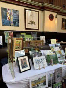 Stall holding frames of painted artwork.